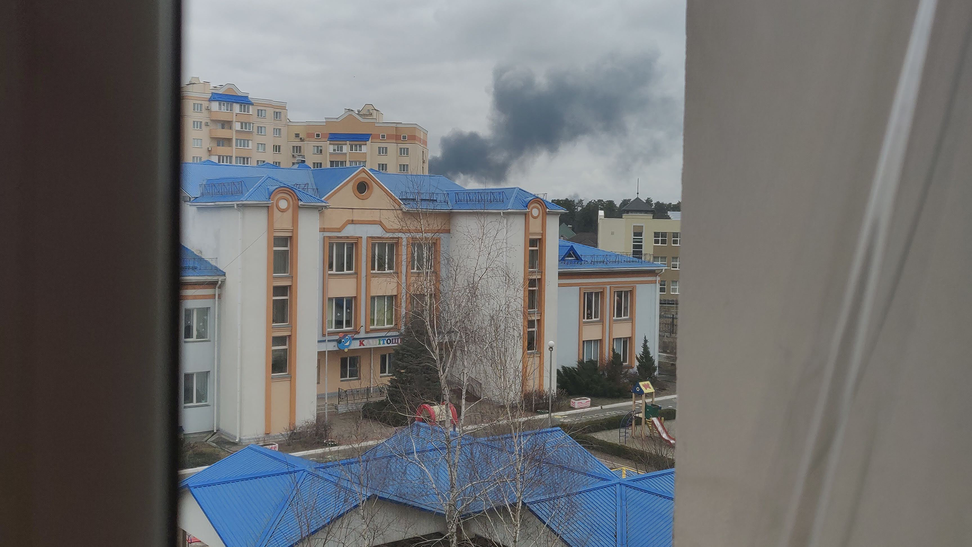 Foto a través de la ventana de Nikita con vista al bombardeo del aeropuerto de Hostomel.