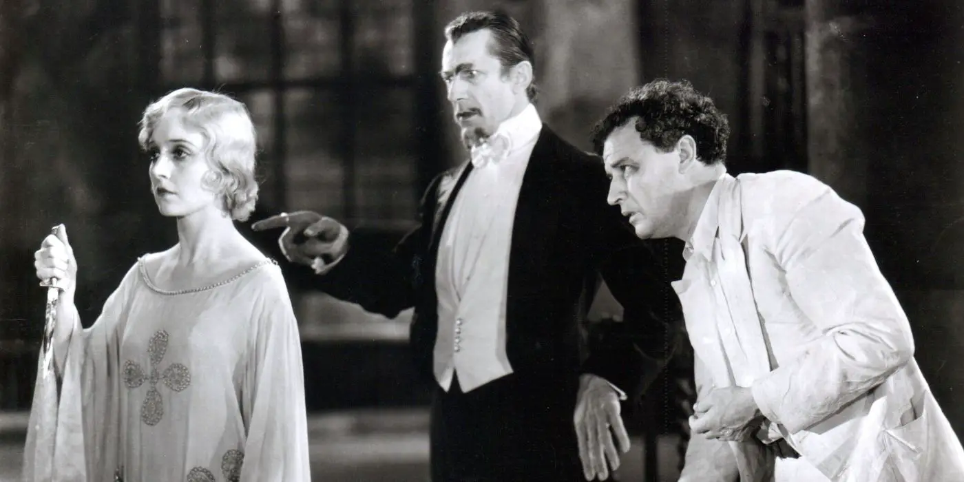 Legendre (Bela Lugosi) y Beaumont (Robert Frazer) miran a Madeline (Madge Bellamy) con horror mientras sostiene un cuchillo con una mirada en blanco en su rostro en White Zombie