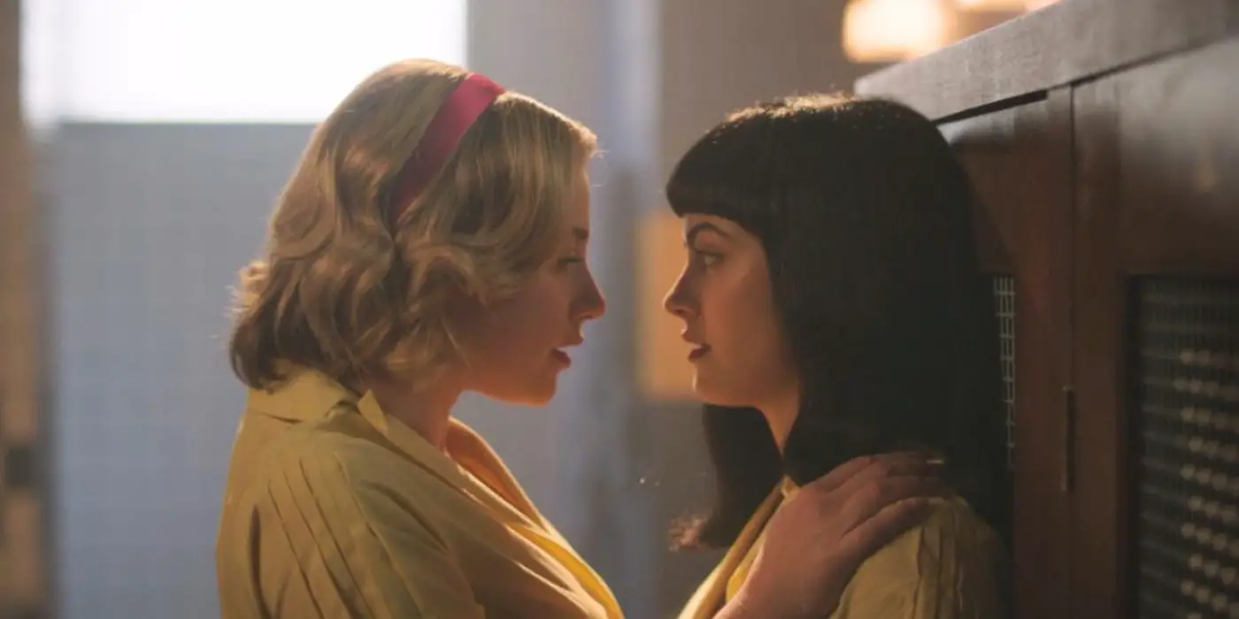 Betty (Lili Reinhart) y Veronica (Camila Mendes) contra los casilleros inclinándose para besarse en la temporada 7 de Riverdale