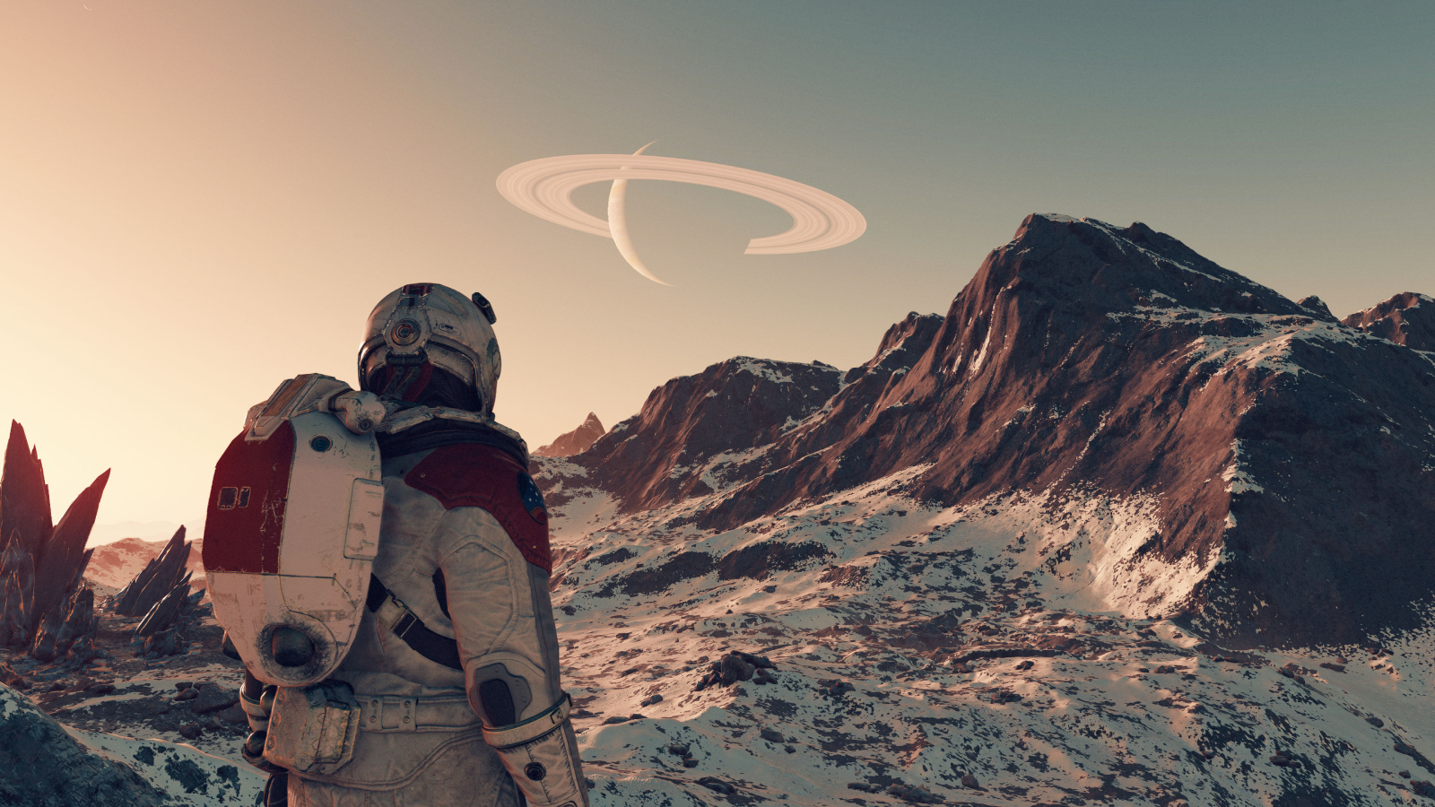 Starfield: una captura de pantalla en tercera persona que muestra a un personaje jugador de Starfield desde atrás mientras observa una cadena montañosa nevada e iluminada por el sol en un mundo alienígena.  Un planeta anillado cuelga en el cielo sobre ellos.