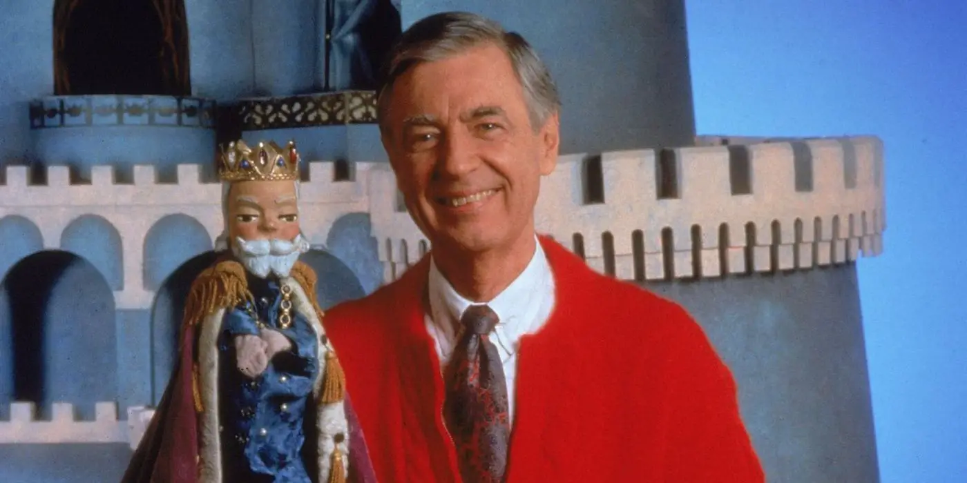 Fred Rogers sonriendo y sosteniendo un rey títere en Mister Rogers' Neighborhood