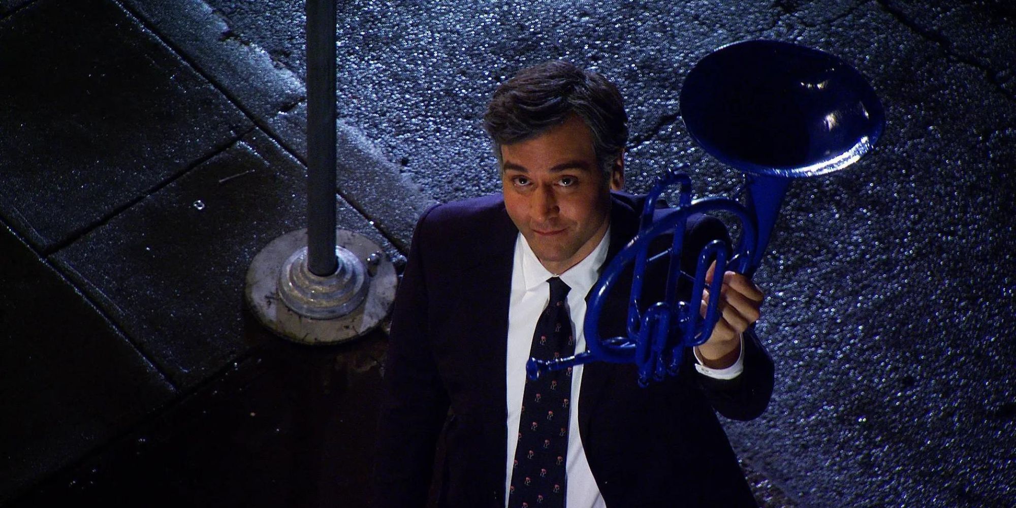 Ted (Josh Radnor) de Cómo conocí a vuestra madre parado debajo del balcón de Robin y sosteniendo una trompa azul