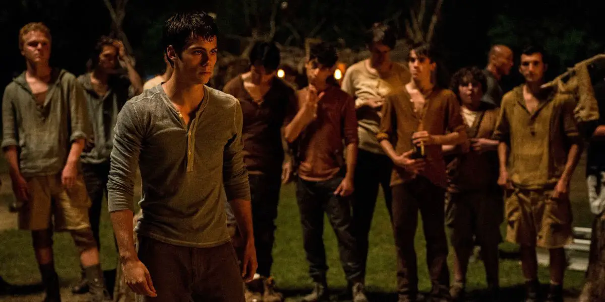 Thomas, interpretado por Dylan O'Brien, parado frente a una multitud de otros chicos en The Maze Runner.
