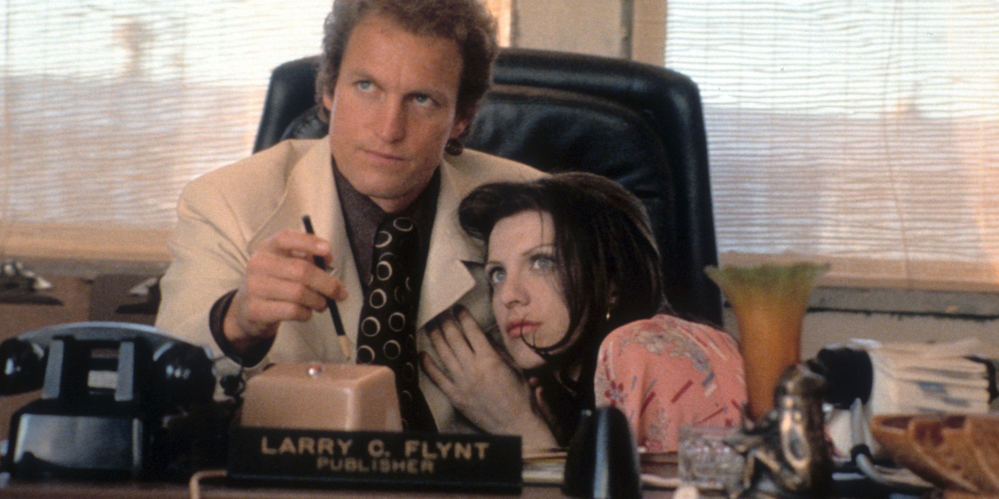 Woody Harrelson y Courtney Love como Larry Flynt y Althea Leasure abrazándose y mirando hacia el futuro en The People vs.Larry Flynt