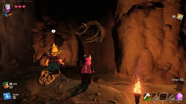 Dos personajes de LEGO Fortnite mirando Knotroot Wood en una cueva. 