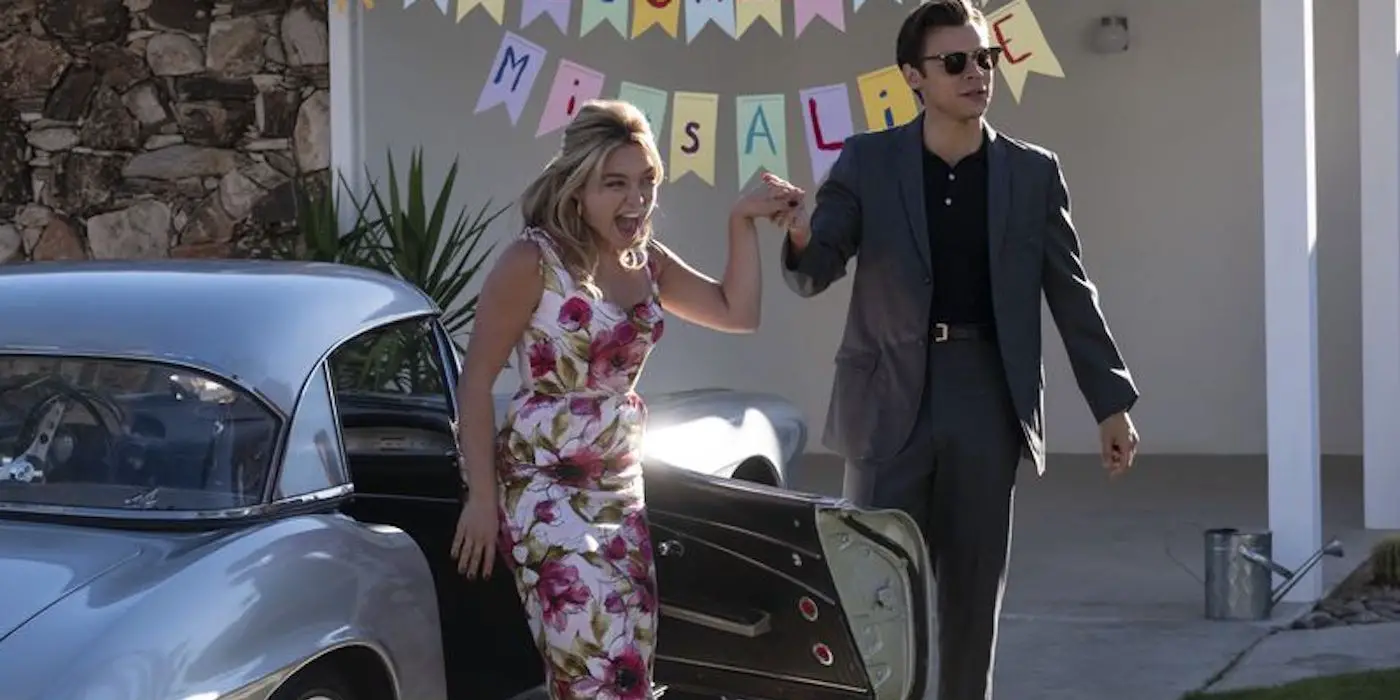 Jack (Harry Styles) ayudando a una emocionada Alice (Florence Pugh) a salir del auto en Don't Worry Darling