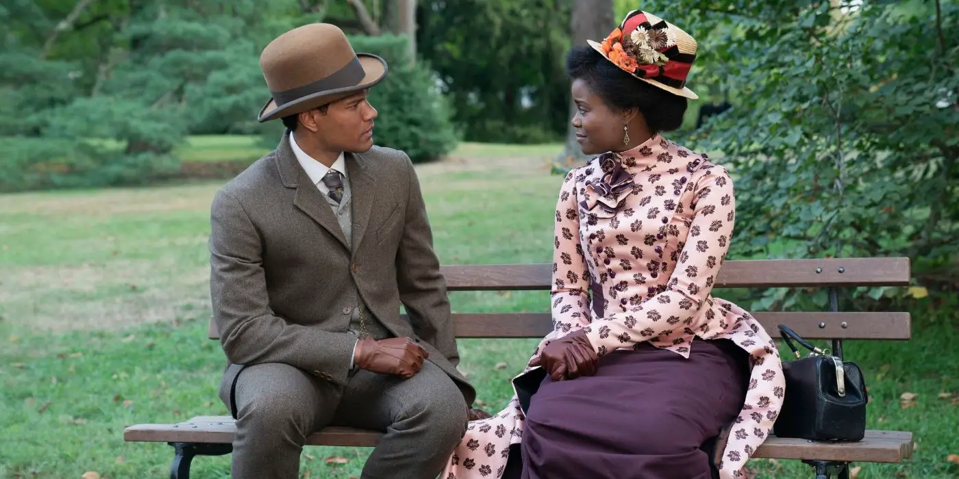 Sullivan Thomas y Denee Benton sentados en un banco del parque en el final de la segunda temporada de The Gilded Age