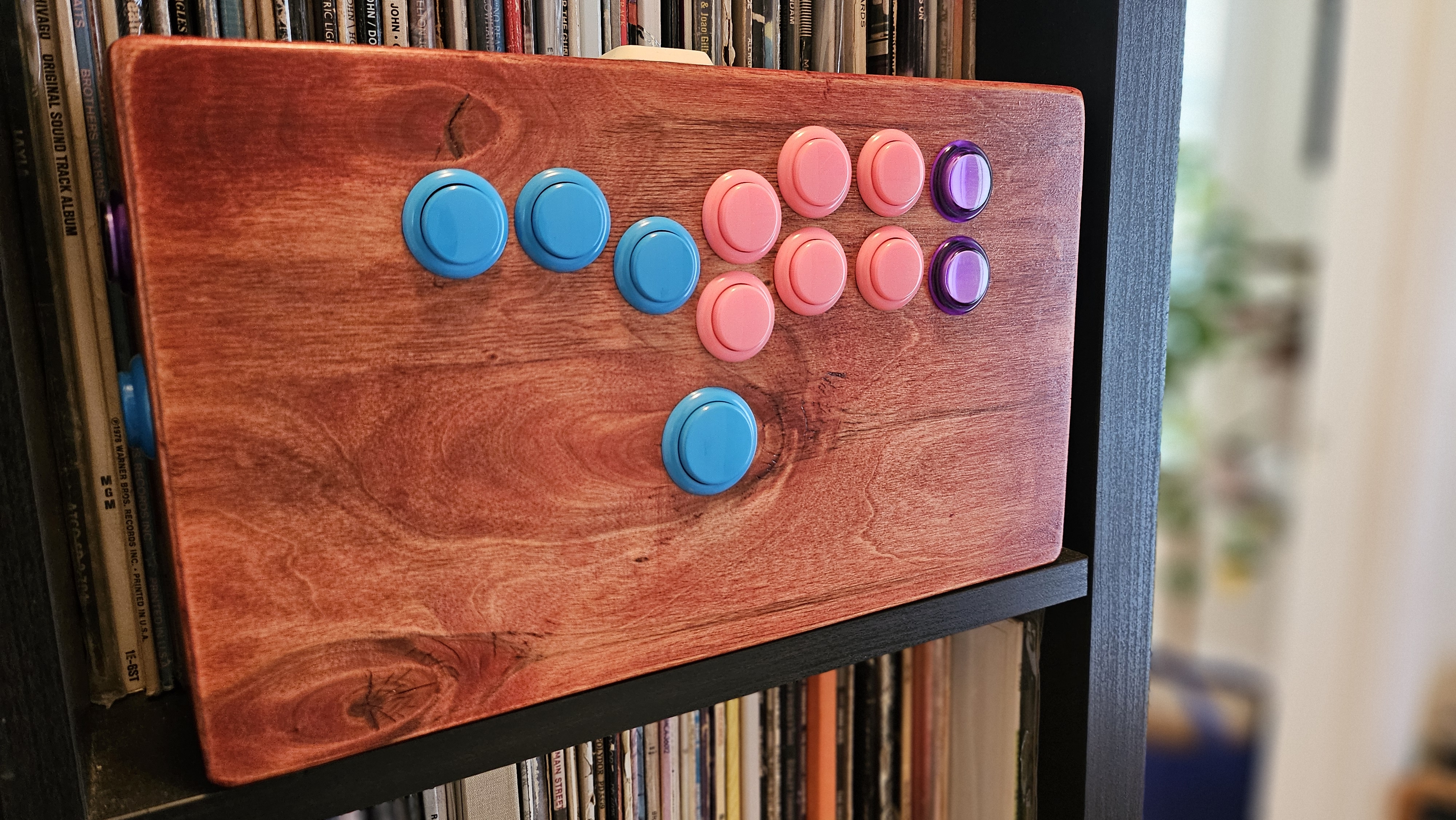 Hitbox de madera personalizado con botones de color chicle en una estantería
