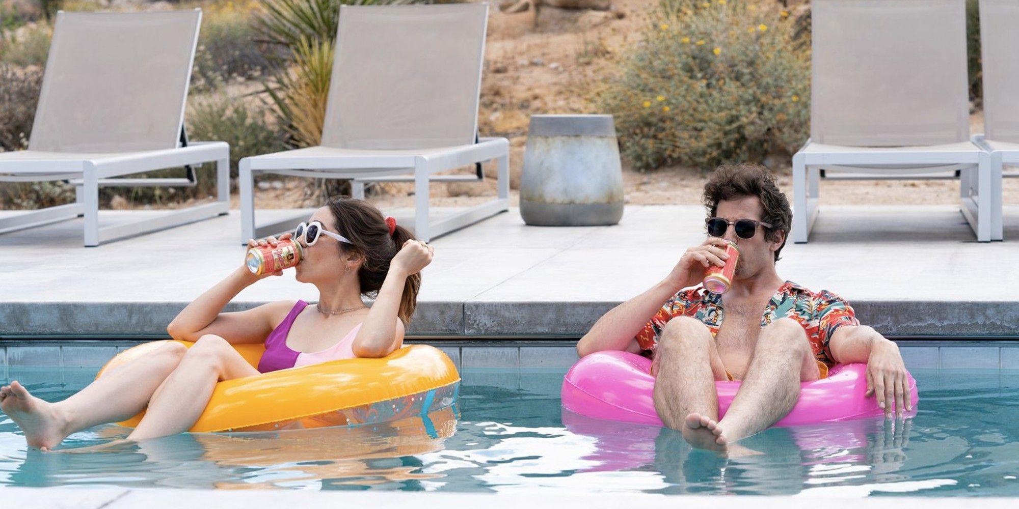 Andy Samberg y Cristin Milioti como Nyles y Sarah bebiendo mientras flotan en una piscina en 'Palm Springs'