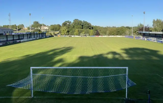 Lakeview Park, un campo de fútbol con dos pequeñas gradas a cada lado y árboles detrás de la portería. 