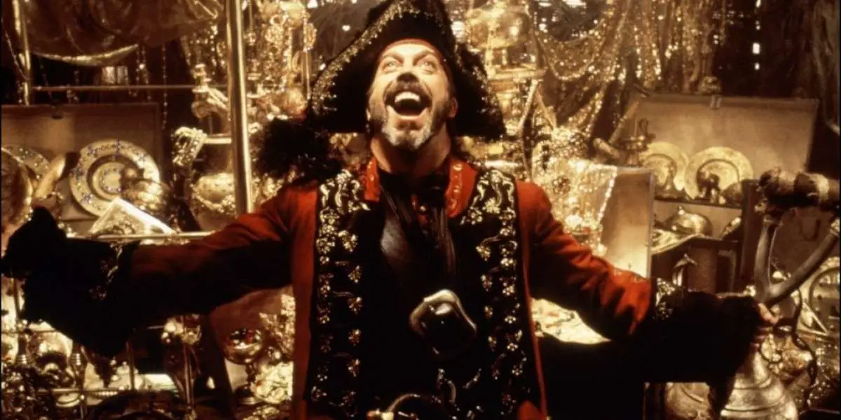 Tim Curry como Long John Silver cantando con los brazos abiertos en Muppet Treasure Island