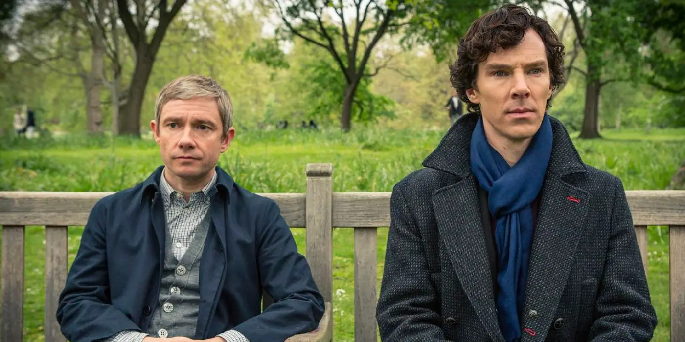 Sherlock Holme y Watson se sientan en un banco del parque y miran hacia adelante en Sherlock.