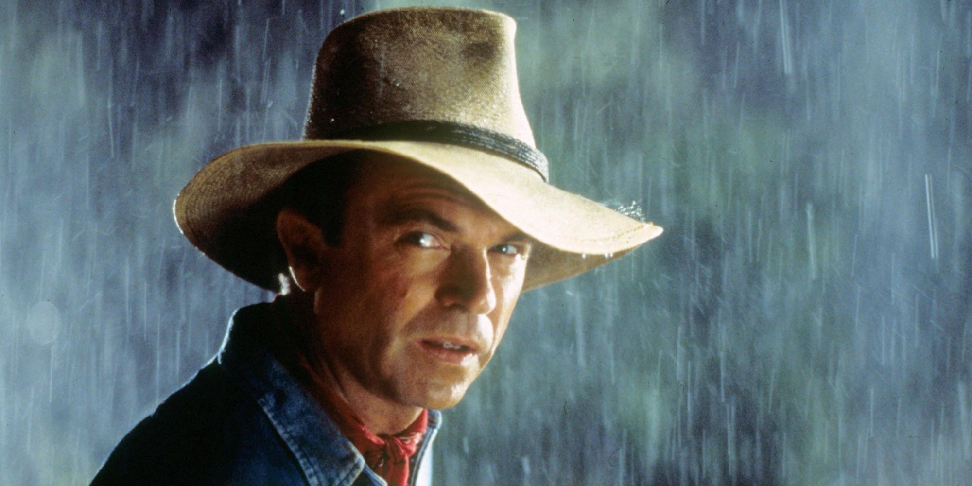 Sam Neill parado bajo la lluvia en Jurassic Park