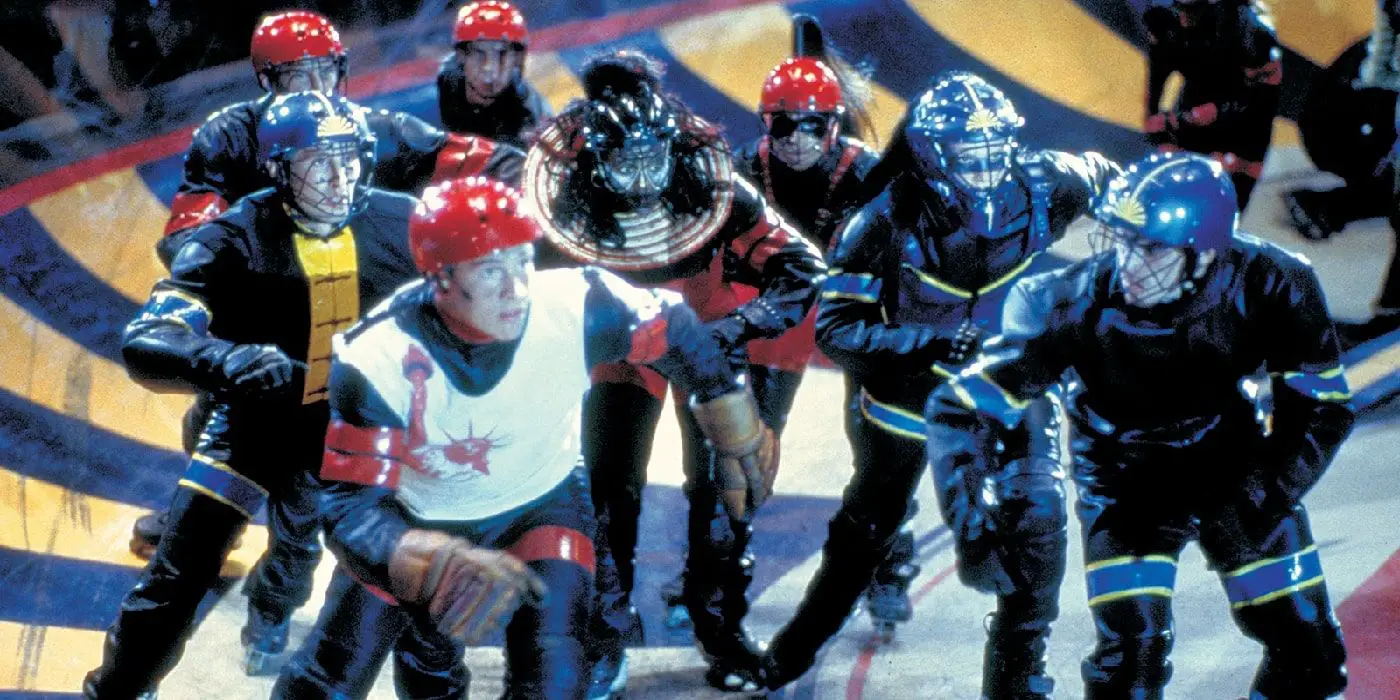Un grupo de participantes patina por la arena en el Rollerball de John McTiernan.