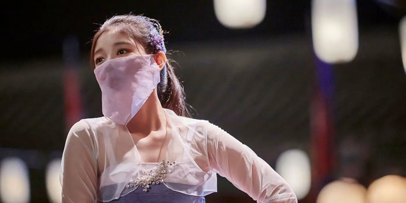 Ra-on (Kim Yoo-jung) bailando con un vestido morado y una máscara a juego que oculta la mitad inferior de su rostro en K-Drama Love in the Moonlight