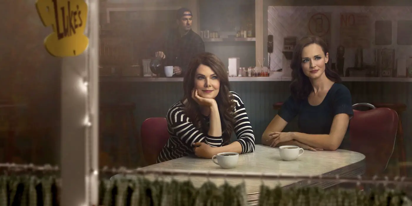 Lauren Graham como Lorelai y Alexis Bledel como Rory sentadas en Luke's Diner con café mientras Scott Patterson como Luke sirve café de fondo en una promoción de Gilmore Girls: A Year in the Life.