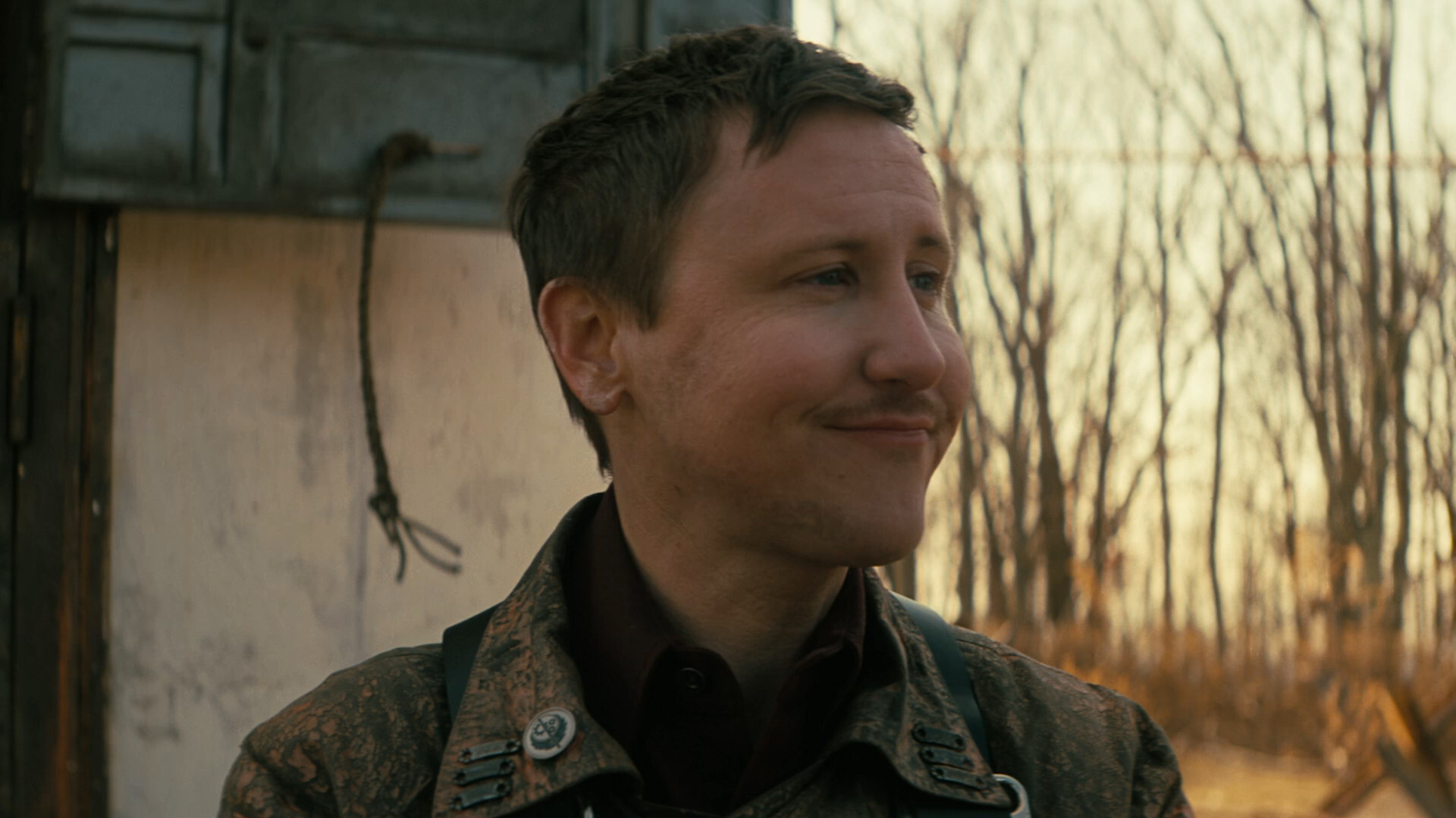 Serie de televisión Fallout: el escudero Thaddeus luce una sonrisa tonta en el páramo