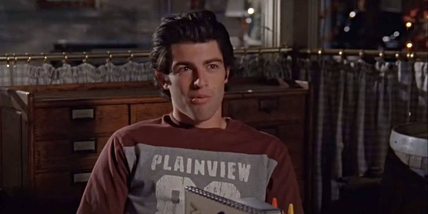 Max Greenfield como Lucas, sentado en una mesa en Luke's Diner en el episodio de Gilmore Girls. "¿Pollo o carne?"