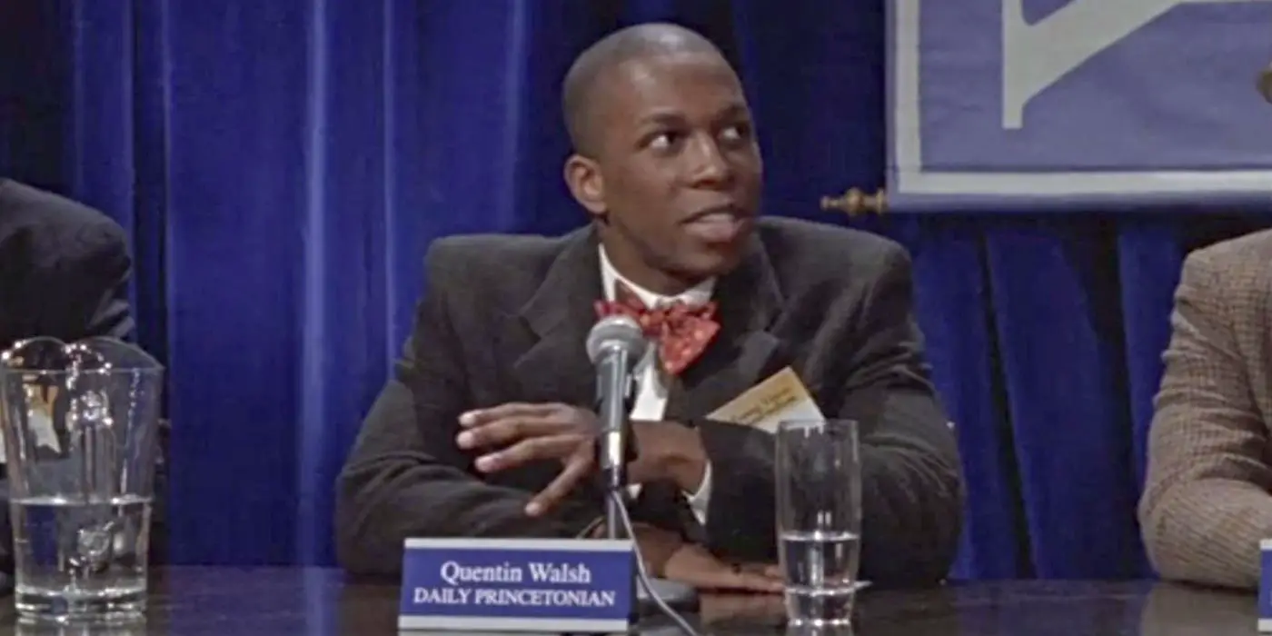 Leslie Odom Jr. como Quentin Walsh, sentado en un panel de periodismo sobre Gilmore Girls