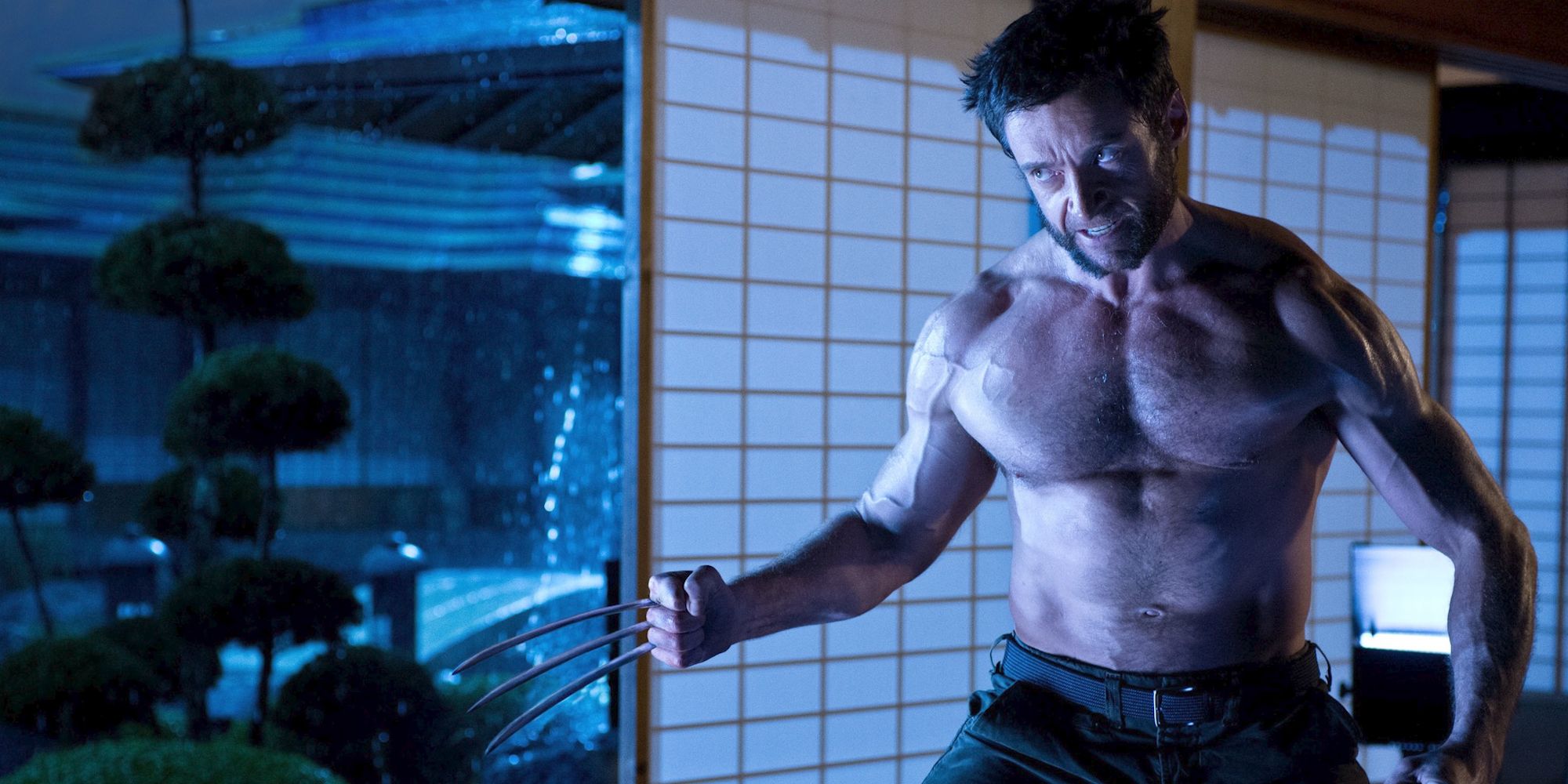 Hugh Jackman como Wolverine con sus garras sin camisa en The Wolverine.
