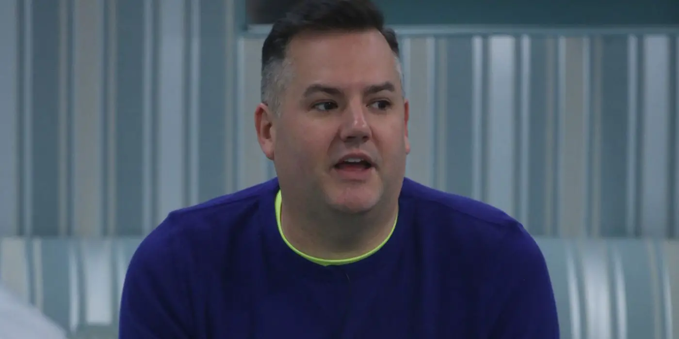 Ross Mathews sentado e inclinado hacia adelante mientras habla en una escena de Celebrity Big Brother.