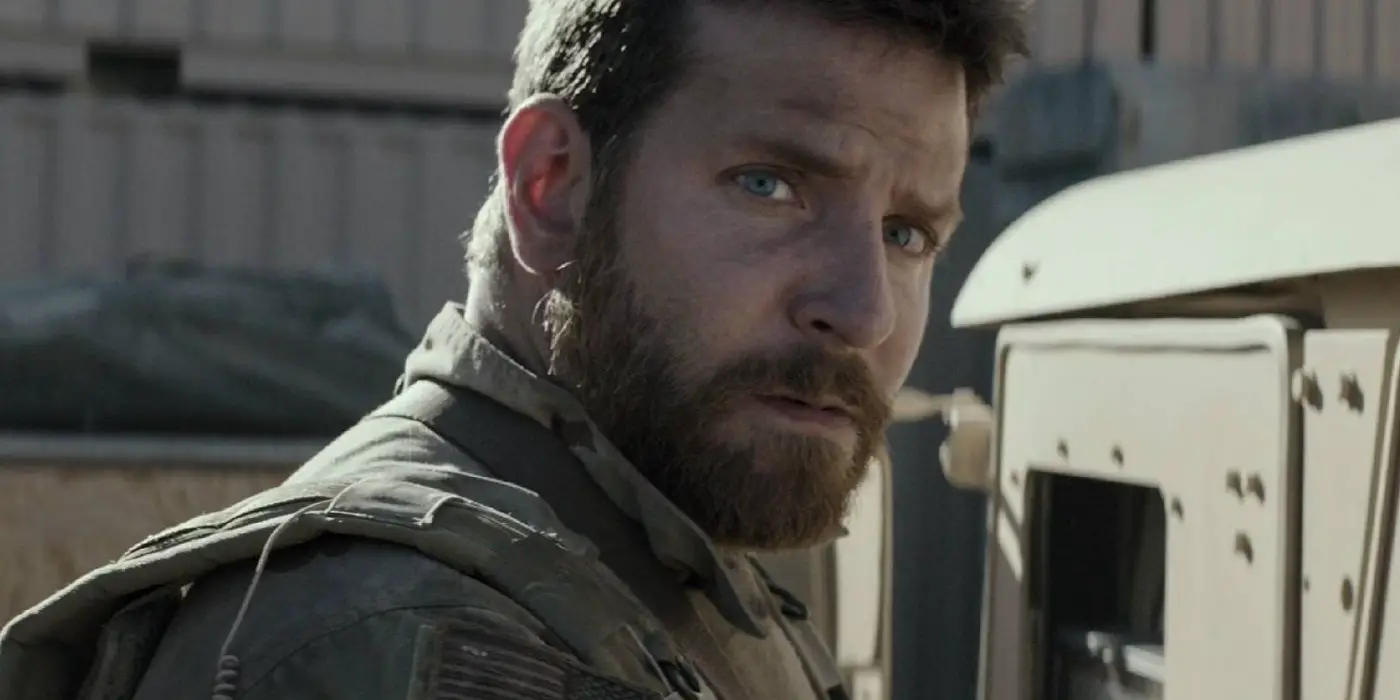 Bradley Cooper con equipo militar mira fuera de cámara en American Sniper
