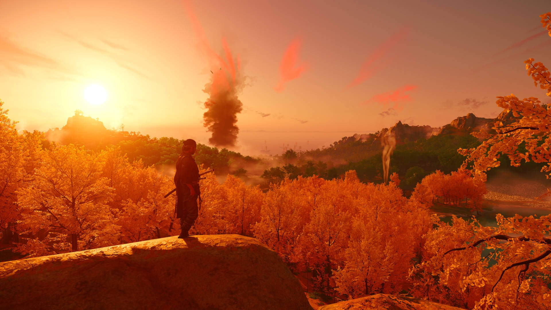 Una captura de pantalla de Ghost of Tsushima, que muestra un paisaje amplio, lleno de árboles y colinas, con el sol poniente proyectando un tono rojo en la vista.