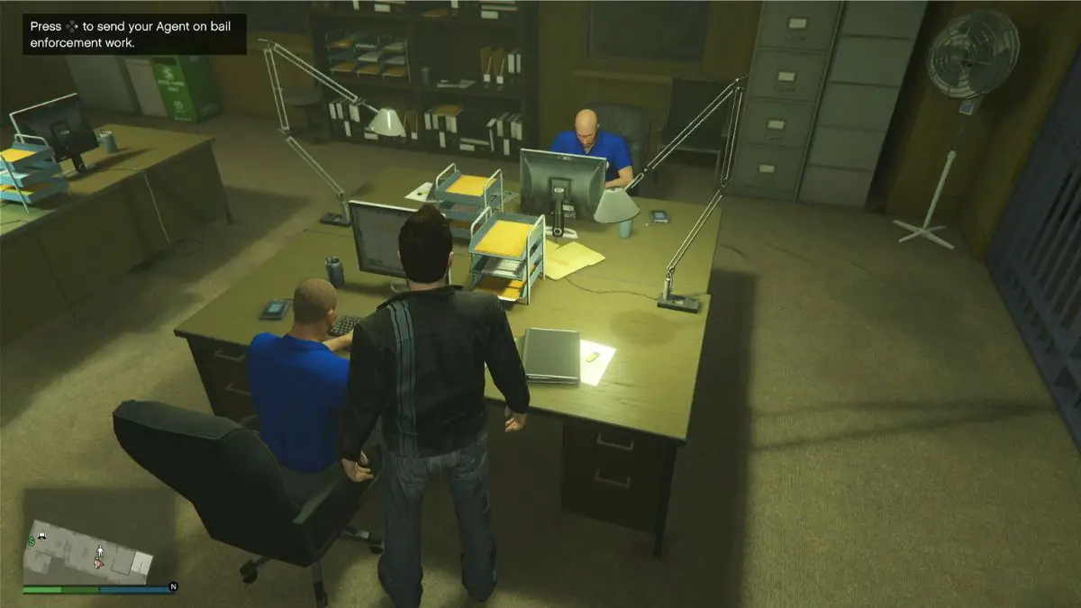 Los agentes de Bottom Dollar Bounties sentados en sus escritorios en la oficina de fianzas. 