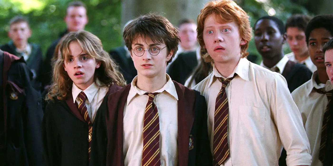 Harry, Hermione y Ron lucen sorprendidos entre una multitud de estudiantes en Hogwarts en El prisionero de Azkaban.